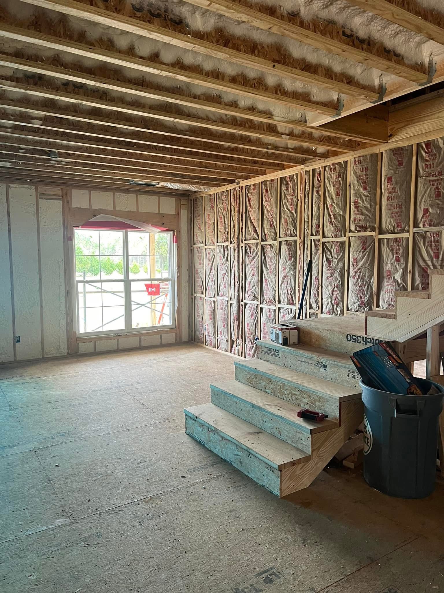 Residential attic with batt insulation on walls before spray foam on roof deck