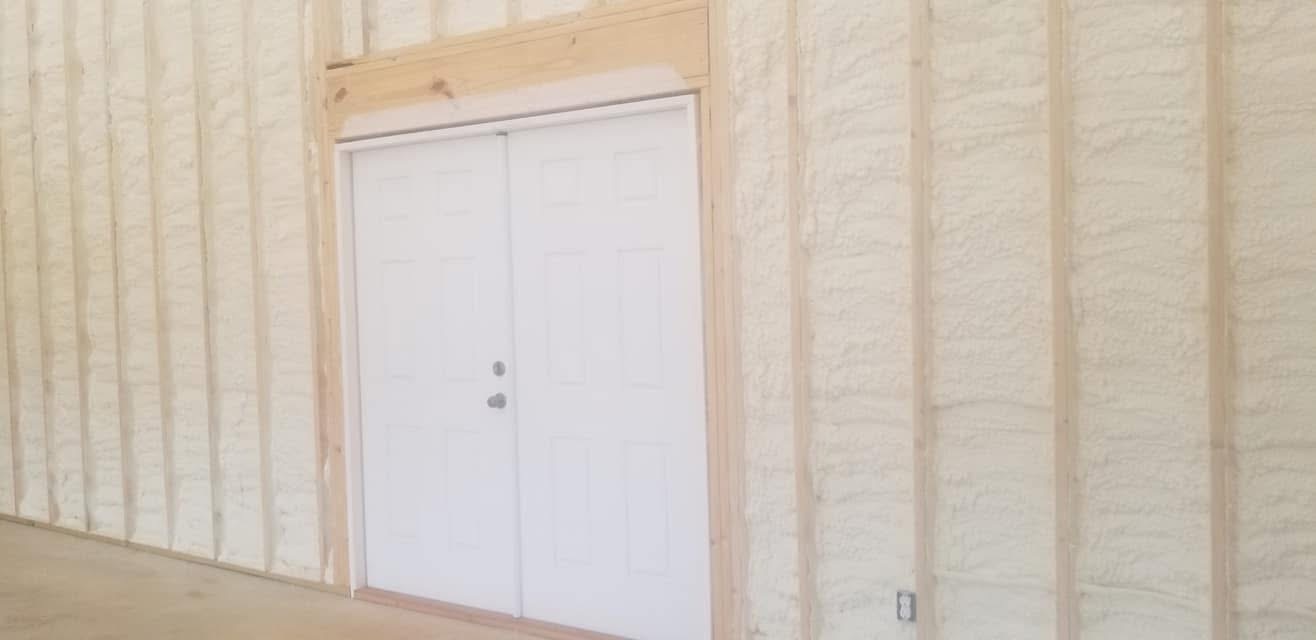 Metal building wall with spray foam applied around double doors