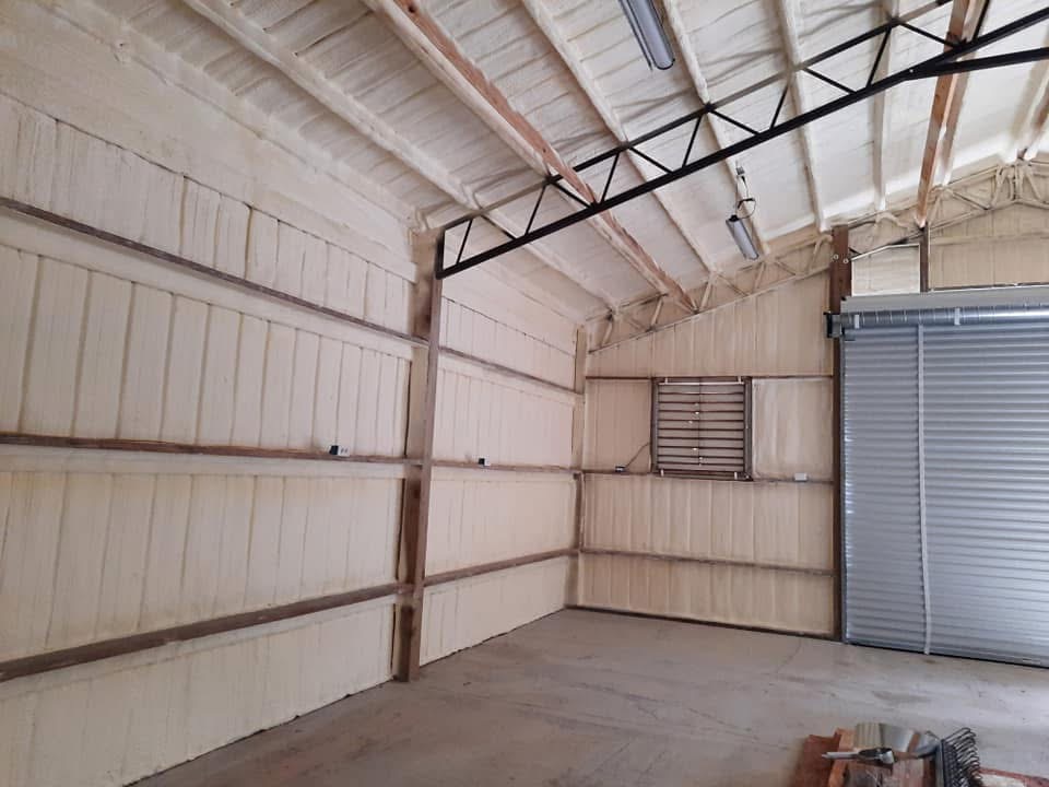 Metal warehouse interior after full spray foam coverage on walls and ceiling
